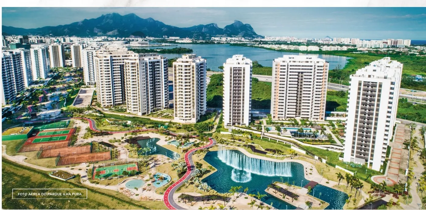 Foto aérea do Parque Ilha Pura com os condomínios, a lagoa e as montanhas